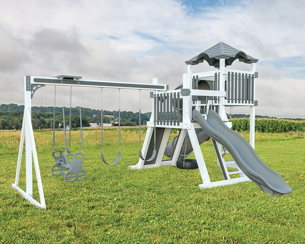 Playground set with swings and slide on a grassy field; white and gray color scheme.