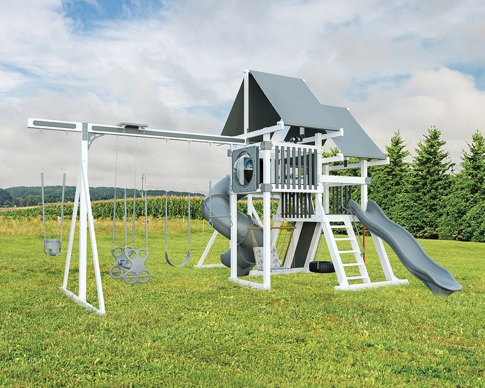 Gray and white playset with swings, slide, and a climbing structure on green grass.