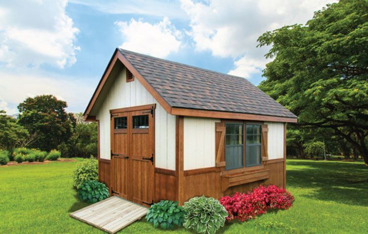 Wooden garden shed with brown trim, white siding, and a shingled roof, set in a green yard with plants.