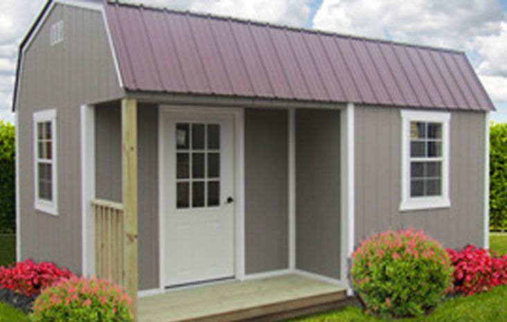 Gray shed with porch and burgundy metal roof; windows and white door.