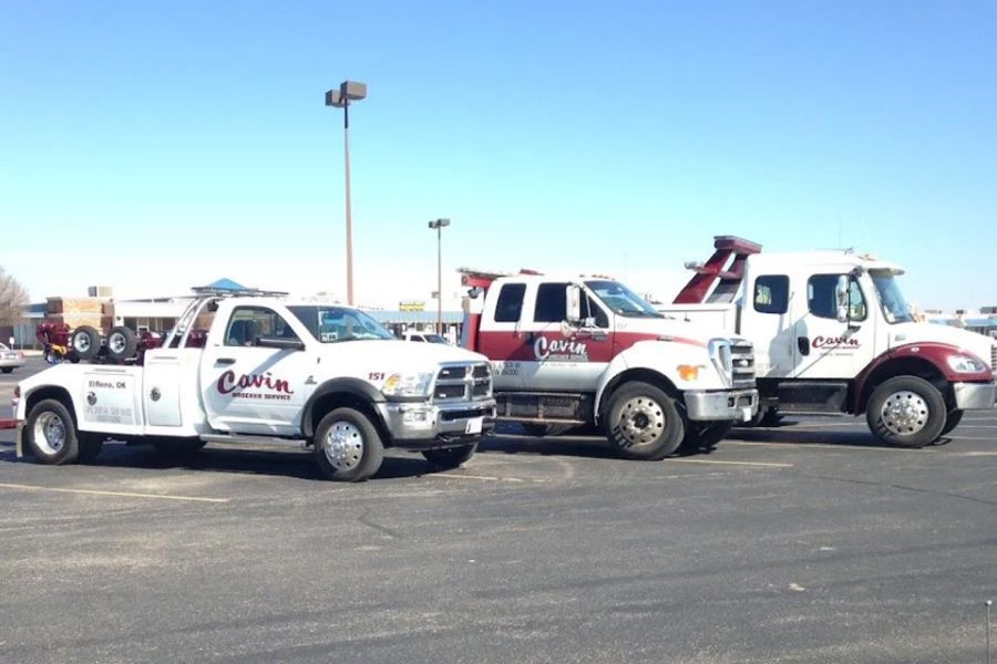 Two tow trucks are parked next to each other in a parking lot