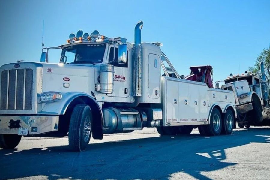 A large tow truck is parked on the side of the road.
