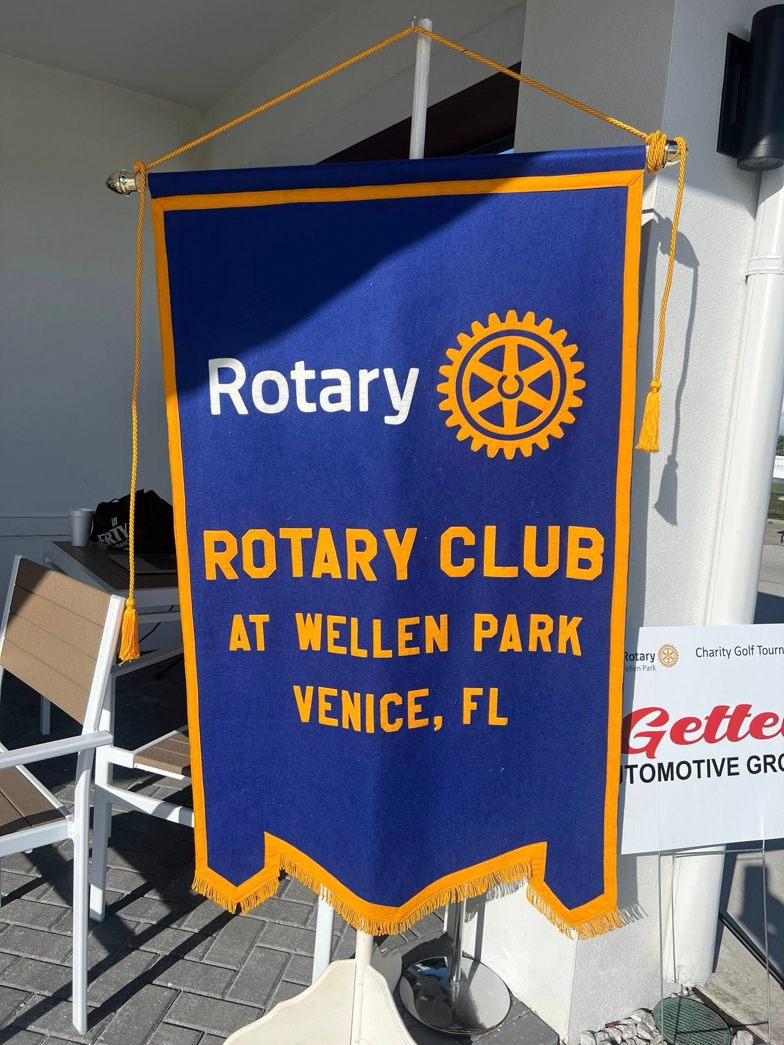 Blue Rotary Club banner with gold fringe reading “Rotary Club at Wellen Park, Venice, FL”