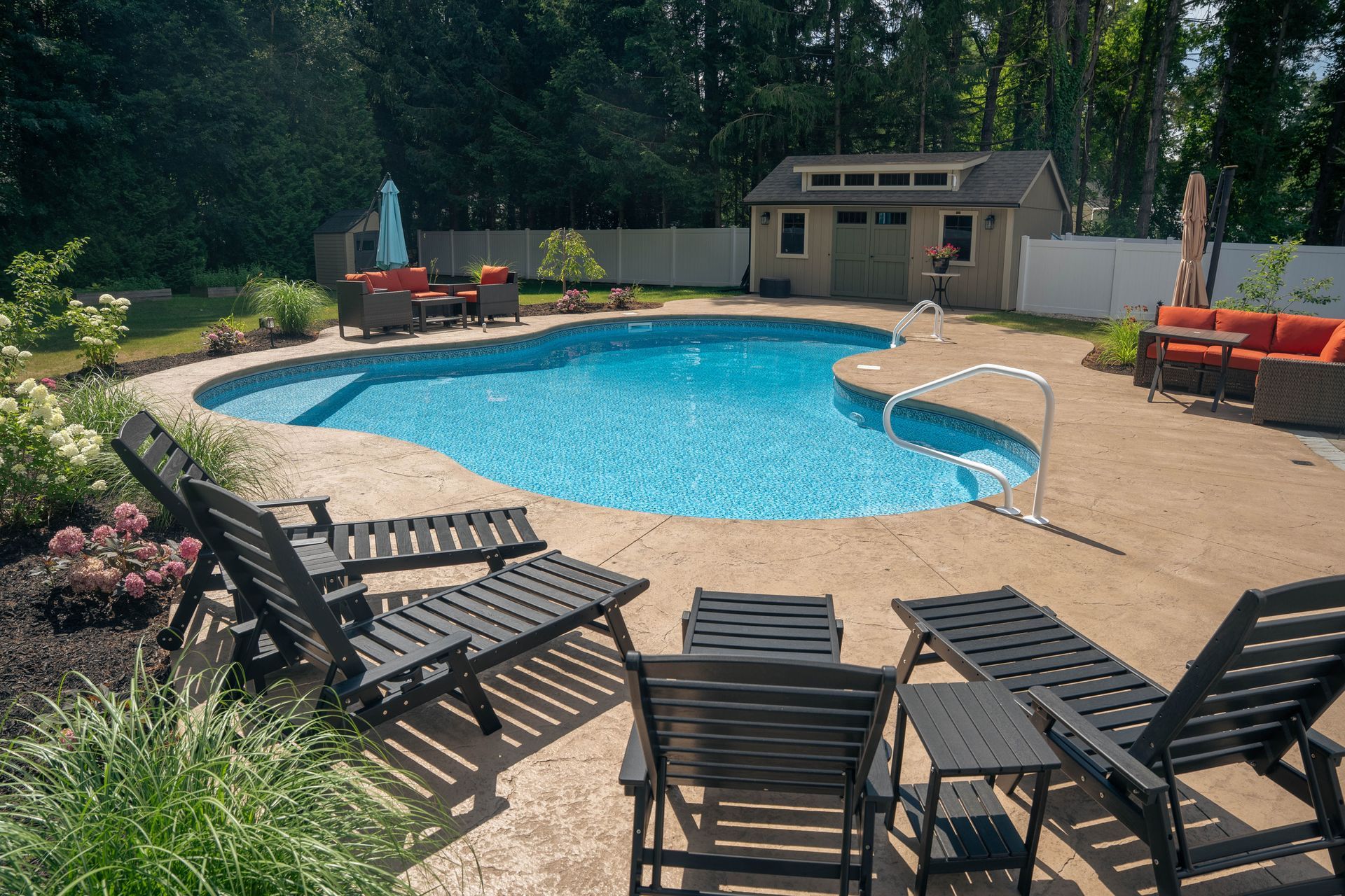 Backyard with a swimming pool, lounge chairs, and outdoor seating. A shed sits in the background.