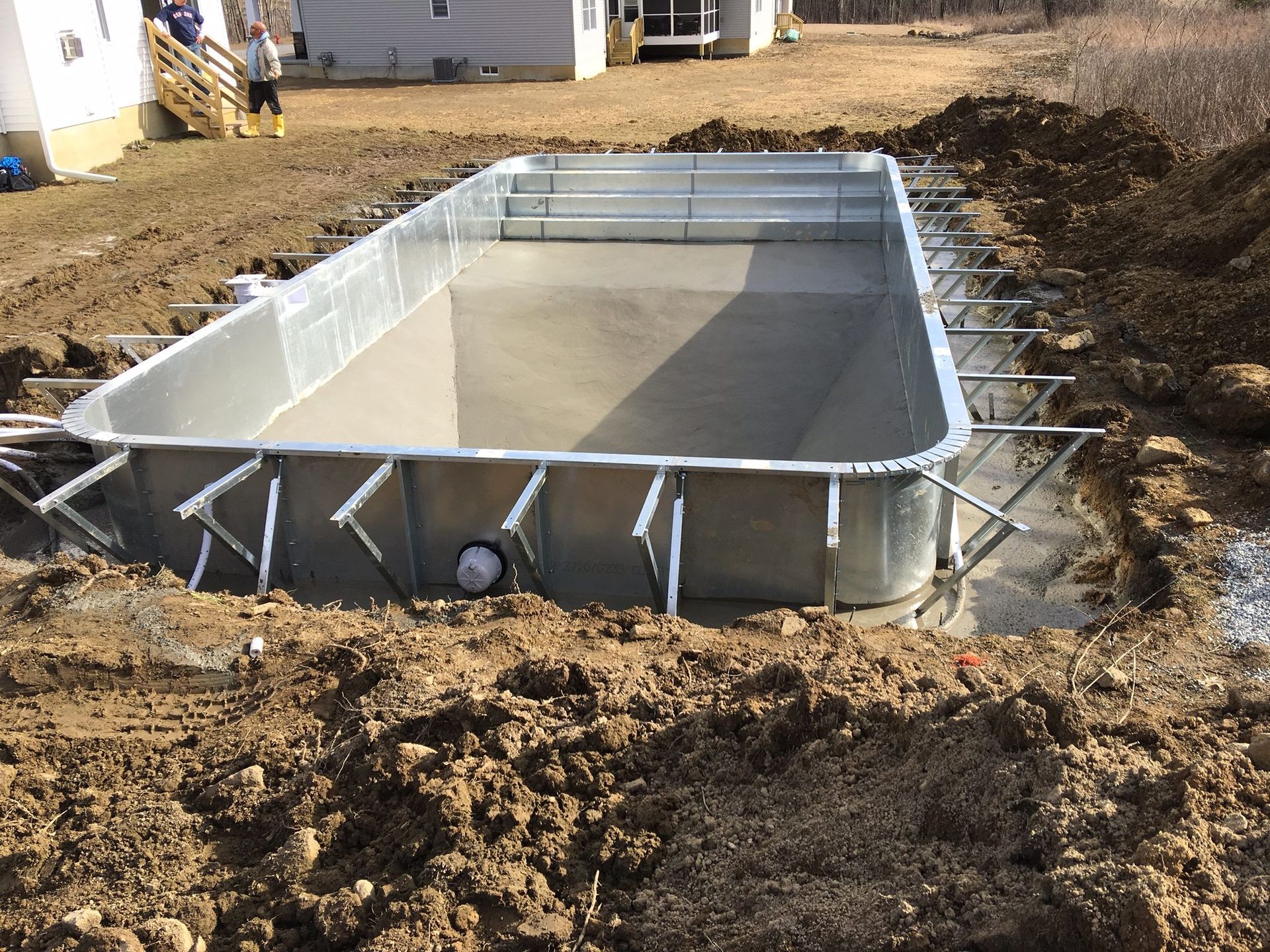 Pool under construction, steel frame in a dirt excavation.