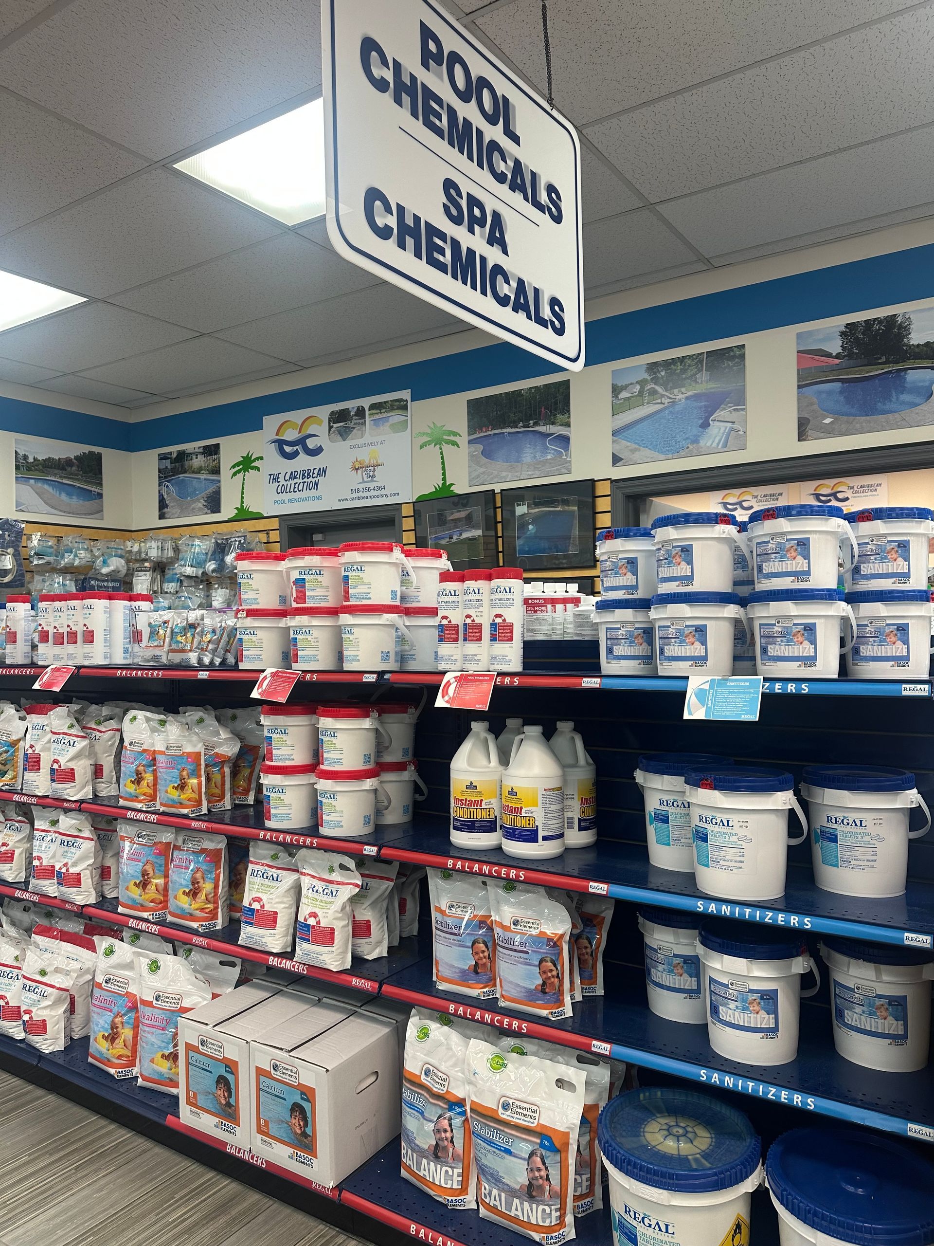 Shelves stocked with pool and spa chemicals in a store, sign overhead.