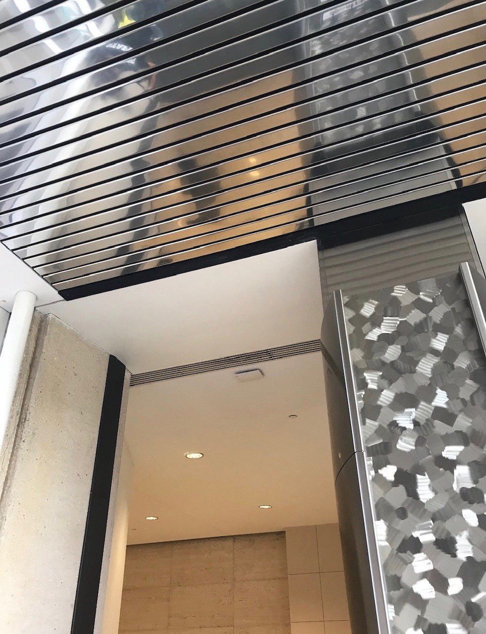 A ceiling with a reflection of a person in it