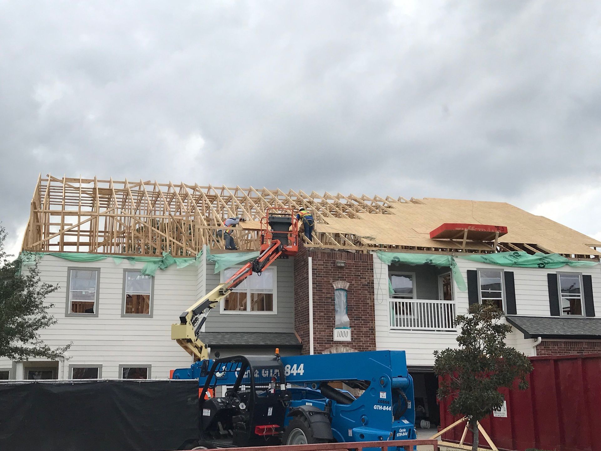 A house is being built with a crane on top of it.
