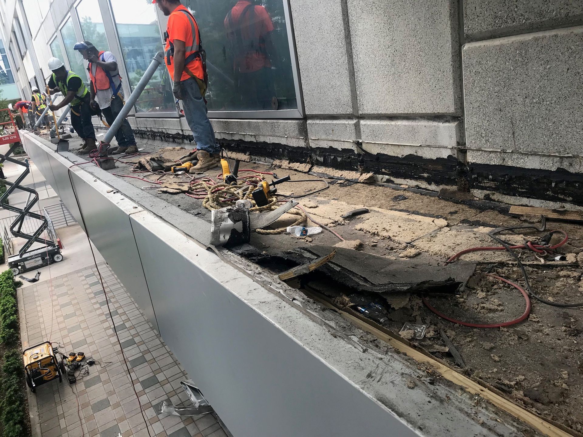 A group of construction workers are working on the side of a building.