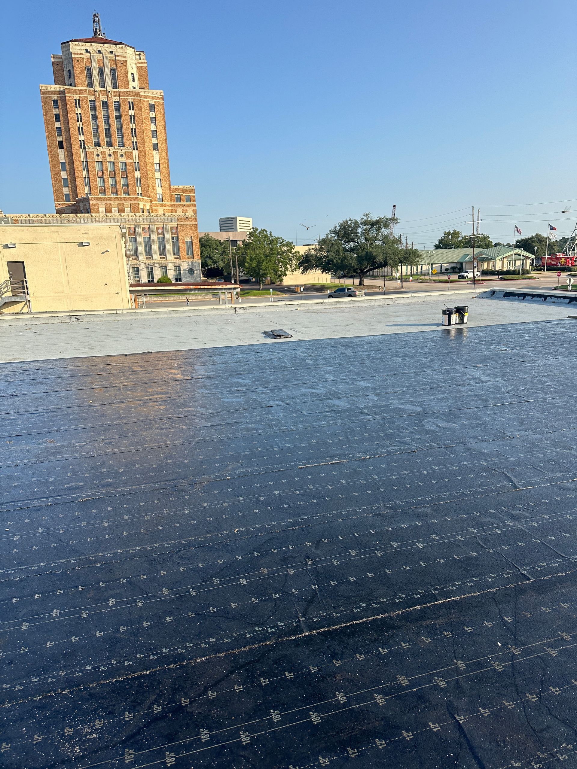 A black roof with a building in the background