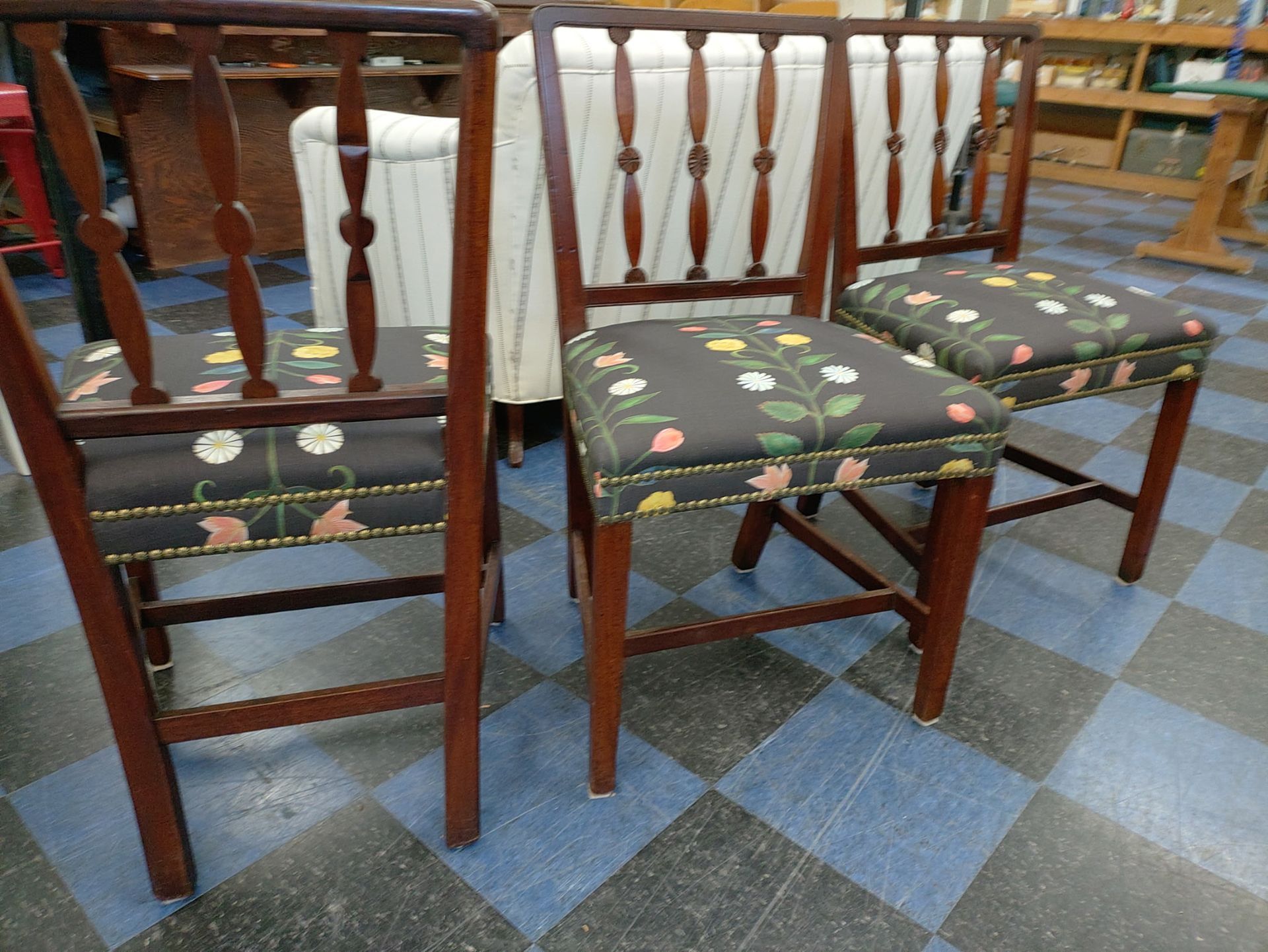 Three chairs are sitting on a checkered floor