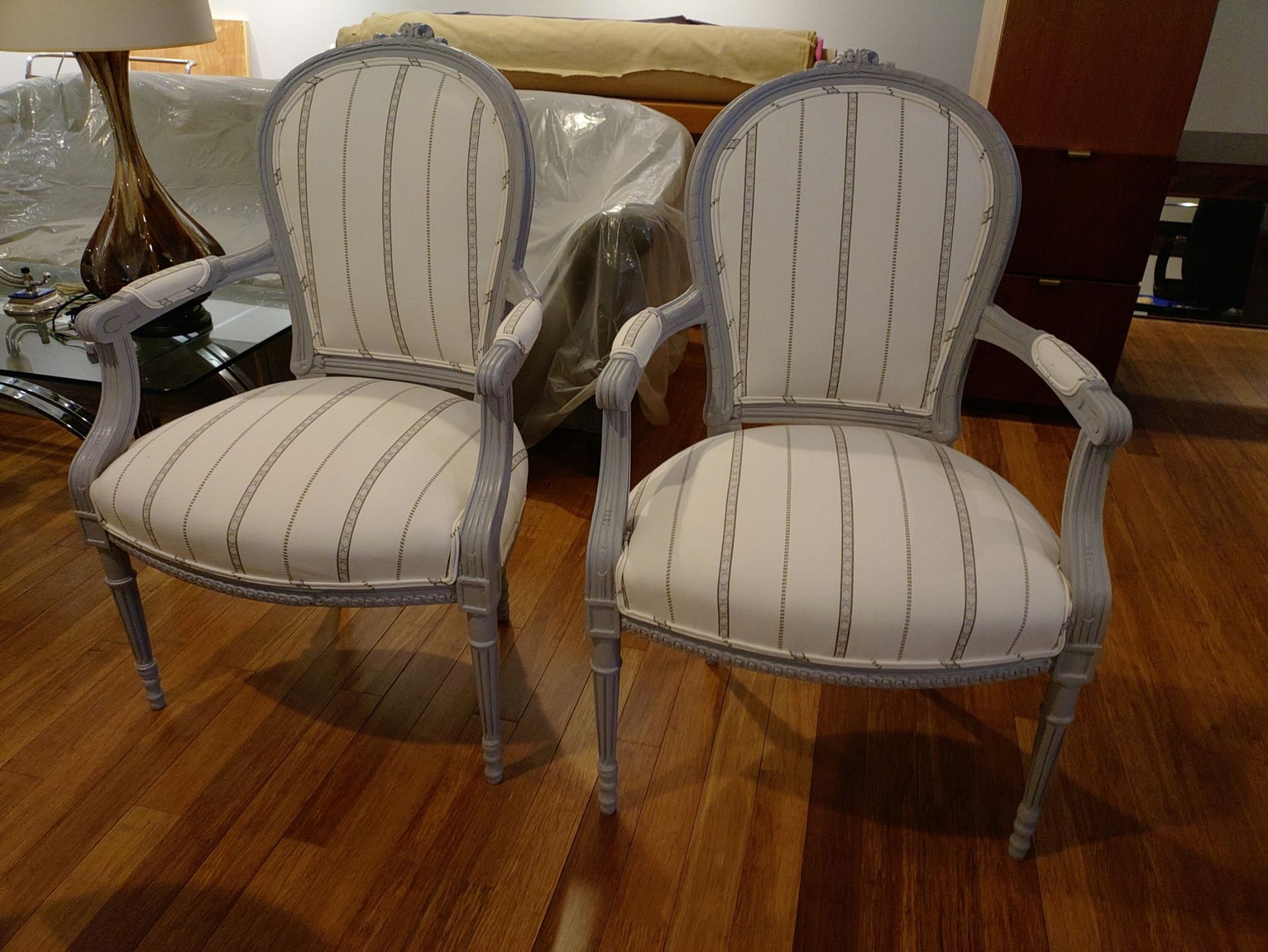 Two chairs are sitting next to each other on a wooden floor.
