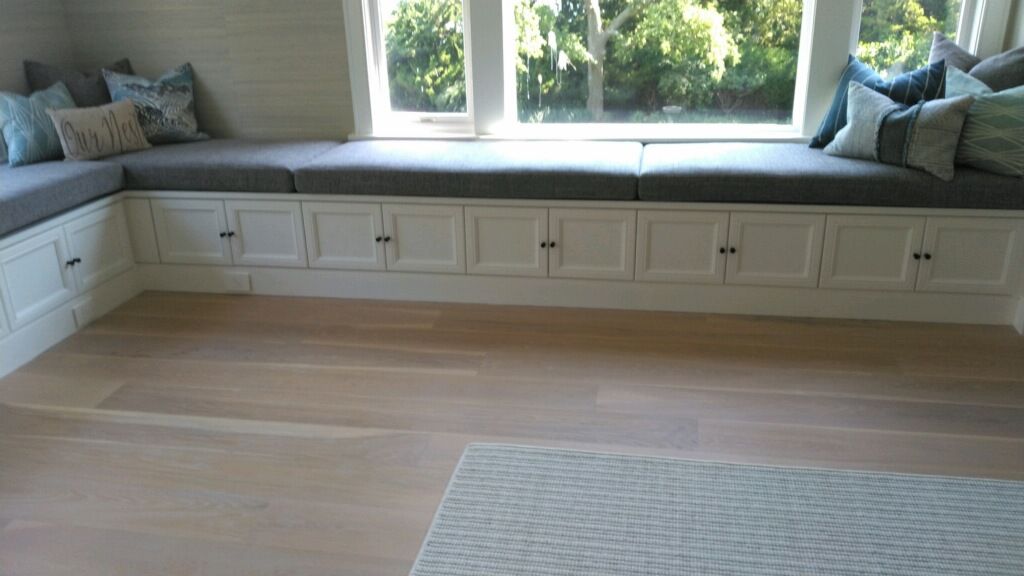 A living room with a window seat and a rug.