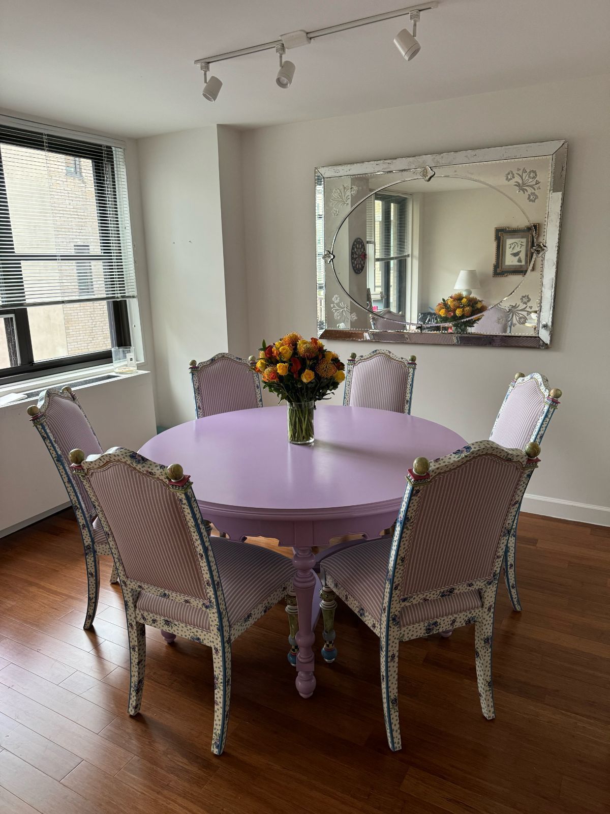 A dining room with a purple table and chairs