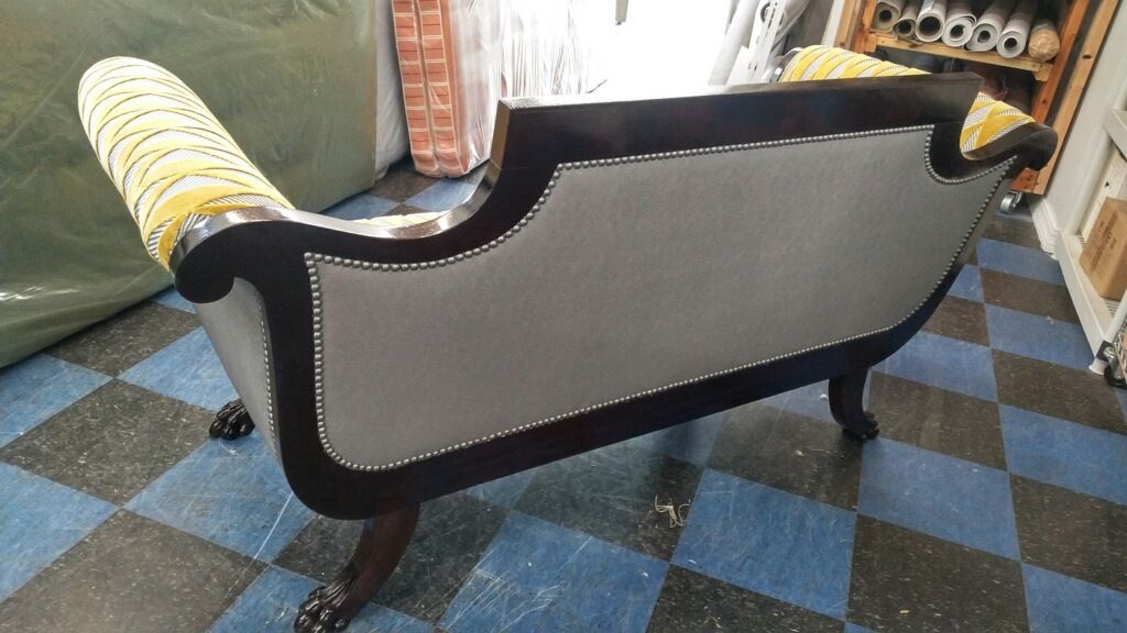 A couch is sitting on a checkered floor in a room