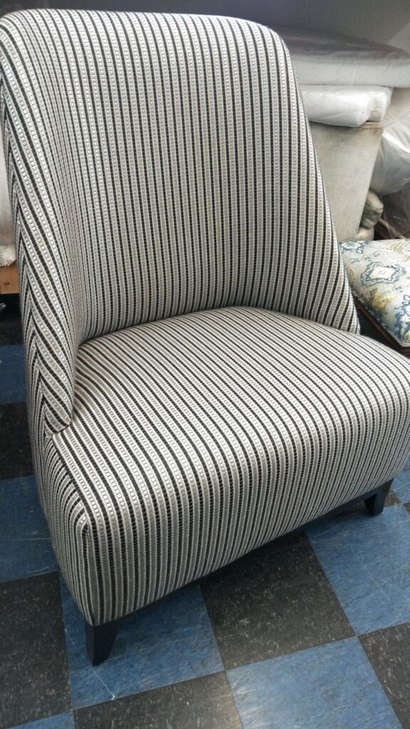 A black and white striped chair is sitting on a checkered floor.