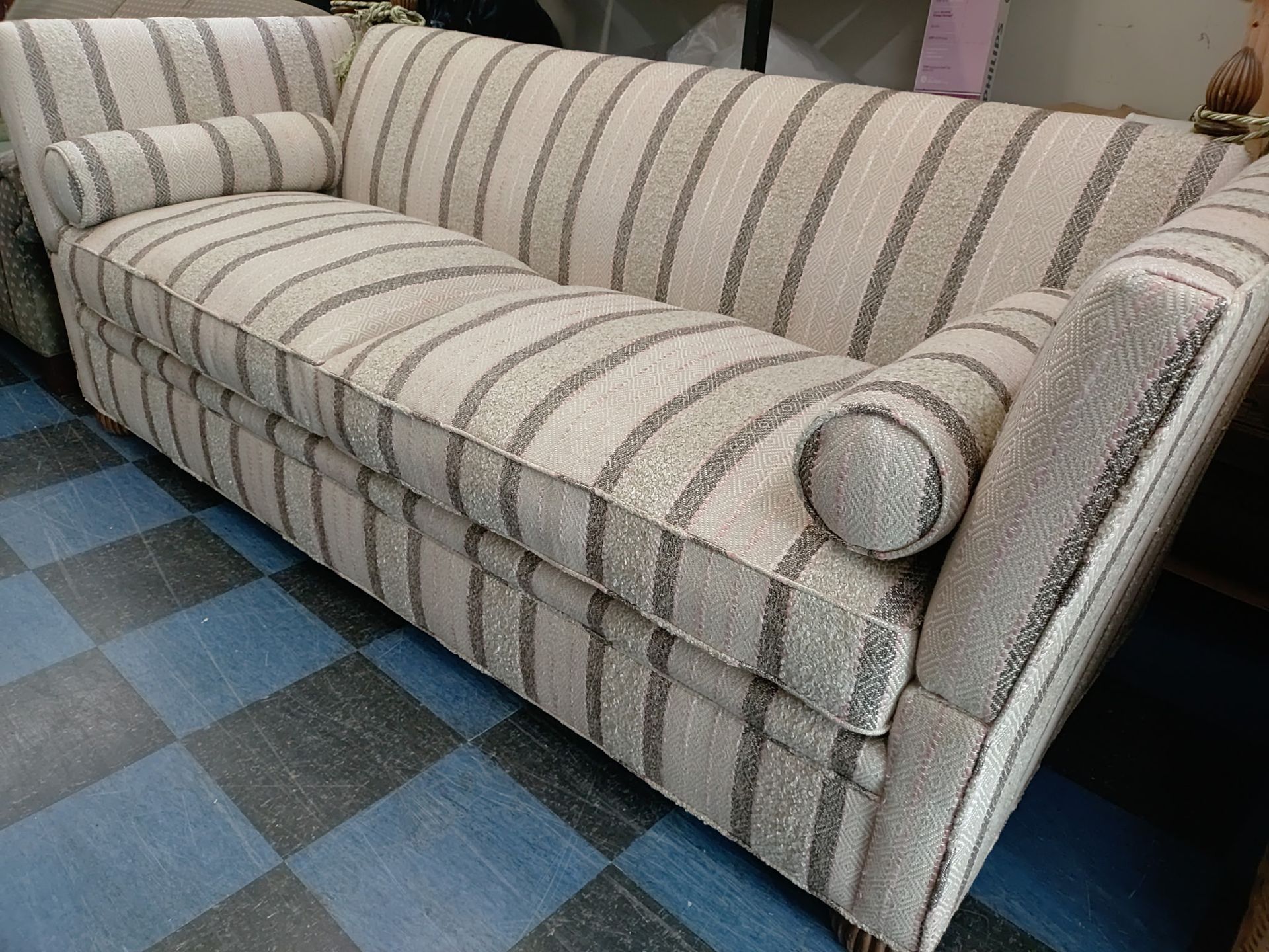 A striped couch is sitting on a checkered floor