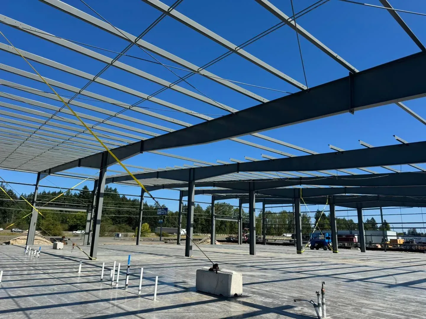 Steel framework of a building under construction against a blue sky.