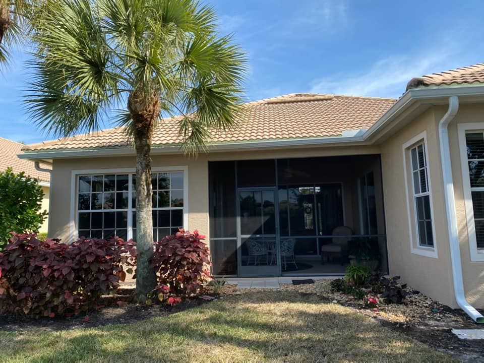 Single-story suburban house with screened patio, palm tree, and landscaped front yard