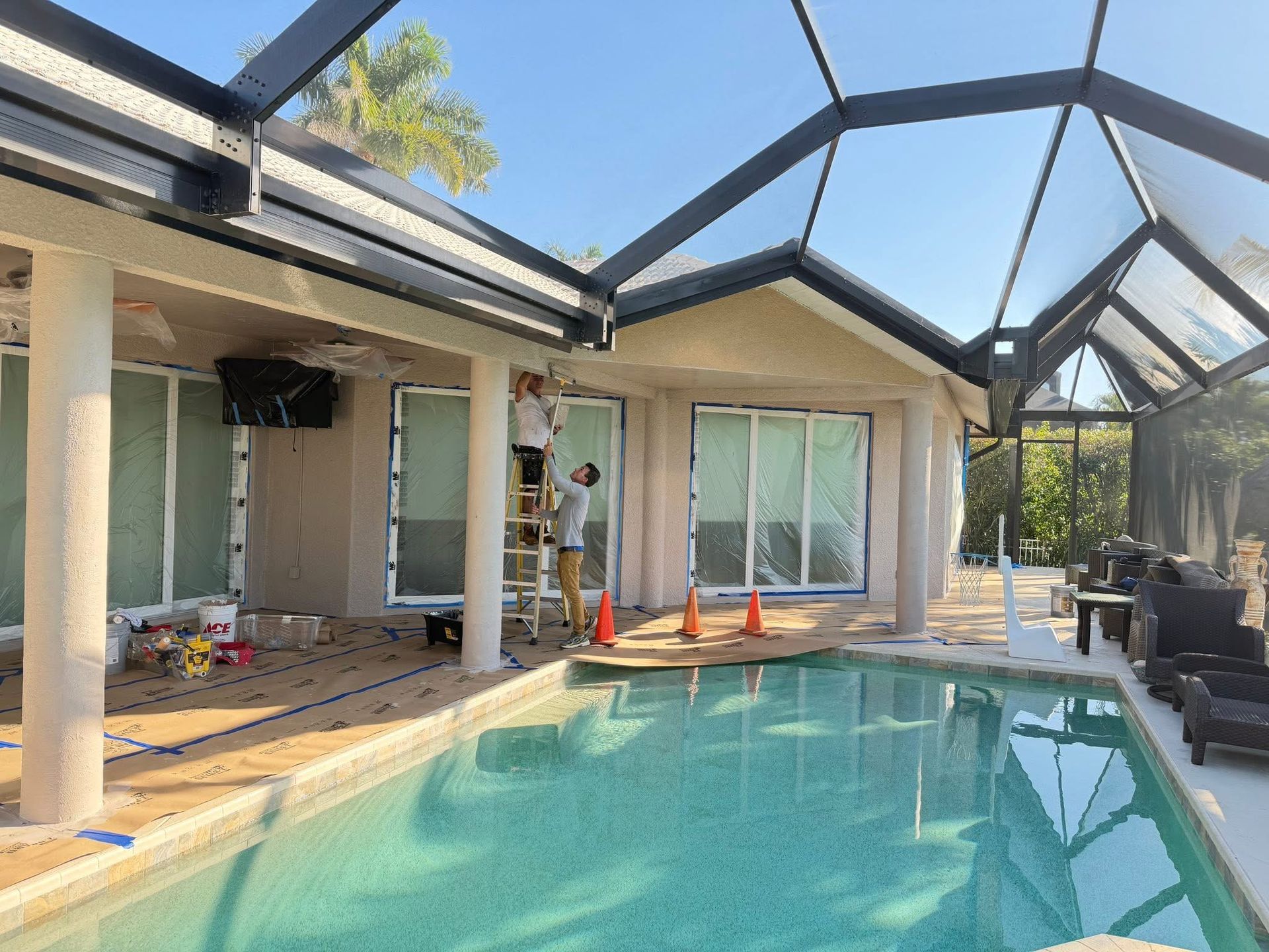 Covered patio with a turquoise pool, glass roof beams, sliding doors, and patio furniture