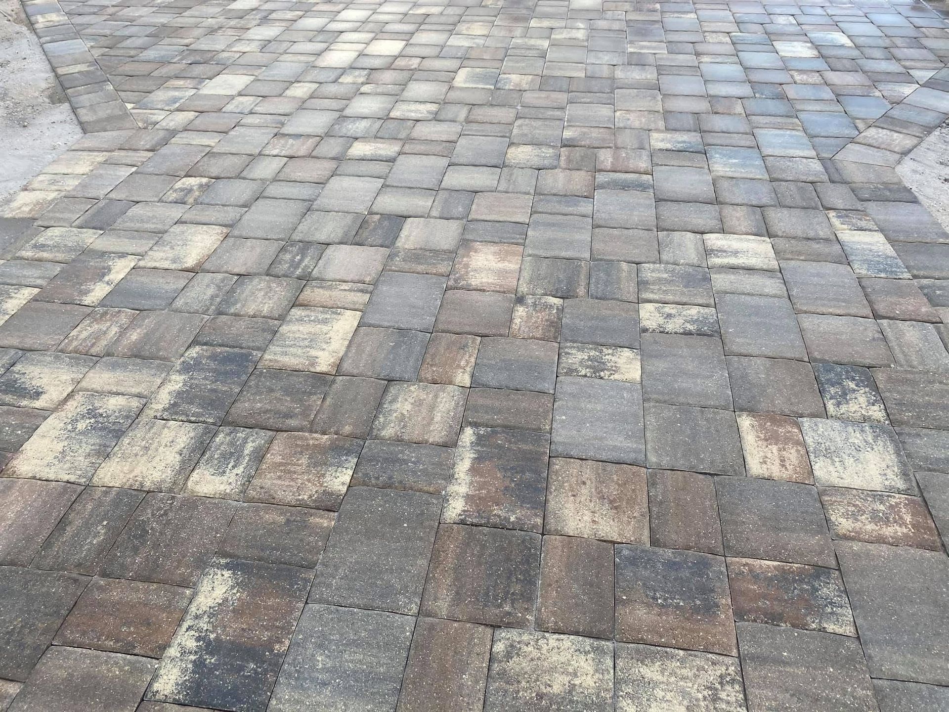 Stone-paved walkway with gray and brown rectangular cobblestones