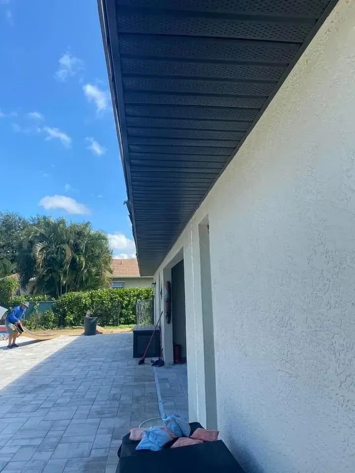 Outdoor patio beside a white building, with a person lying on the ground in the foreground.