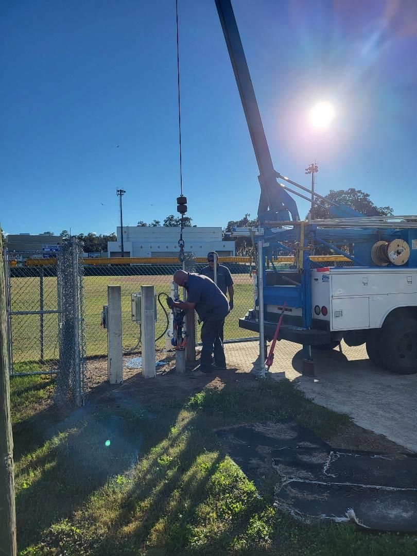 A man is standing next to a truck with a crane attached to it.