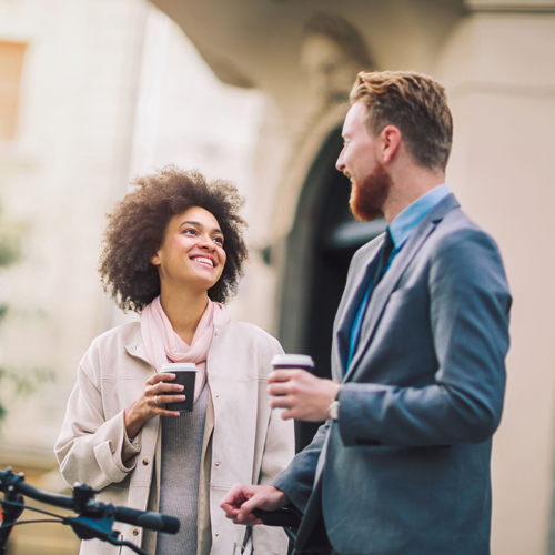 A man and a woman are standing next to each other and talking