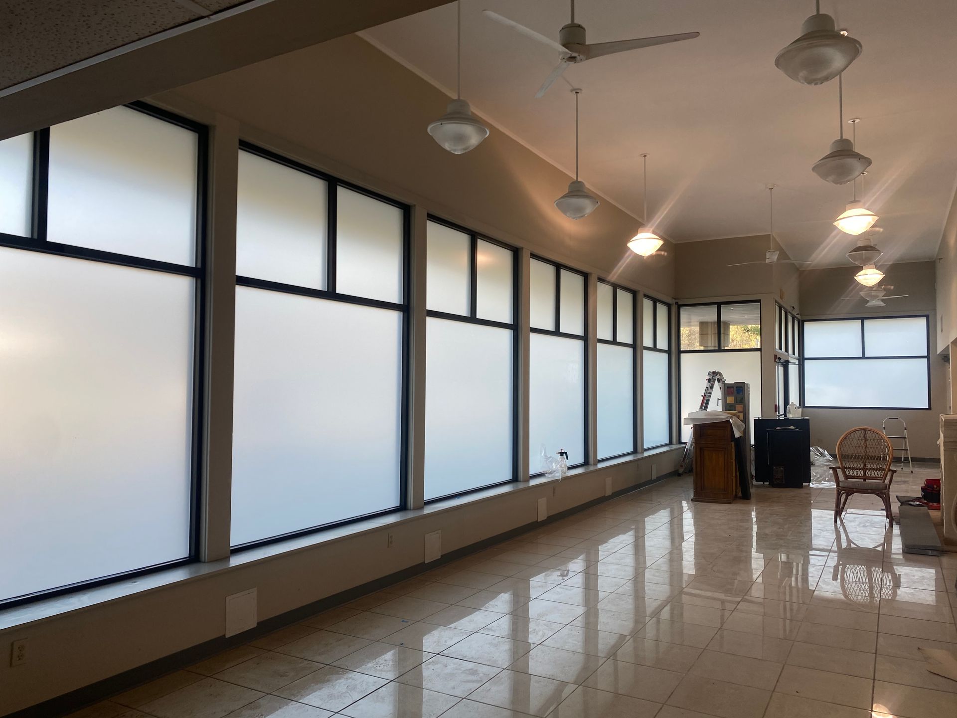 A long hallway with lots of windows and a piano