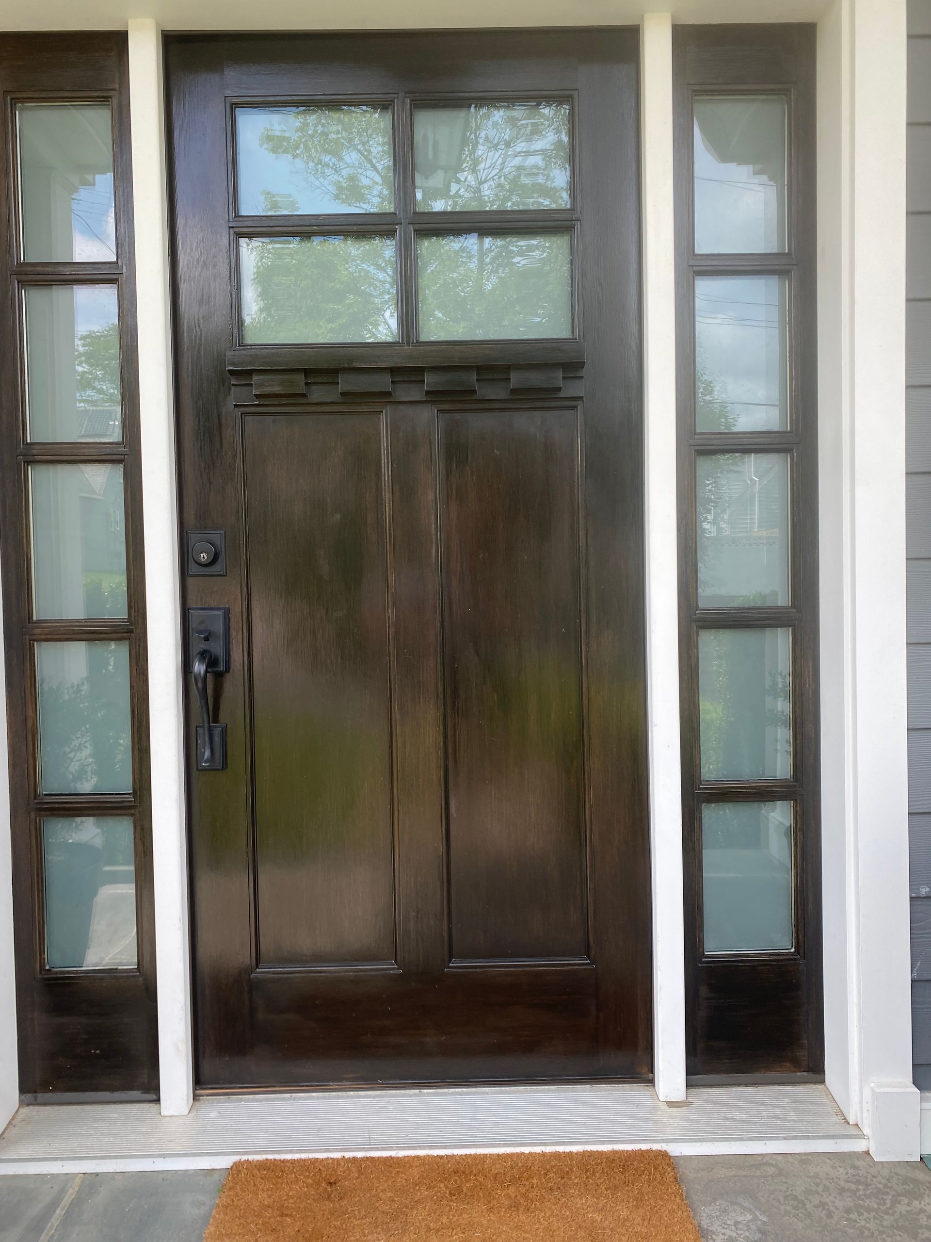 A brown door with a doormat in front of it