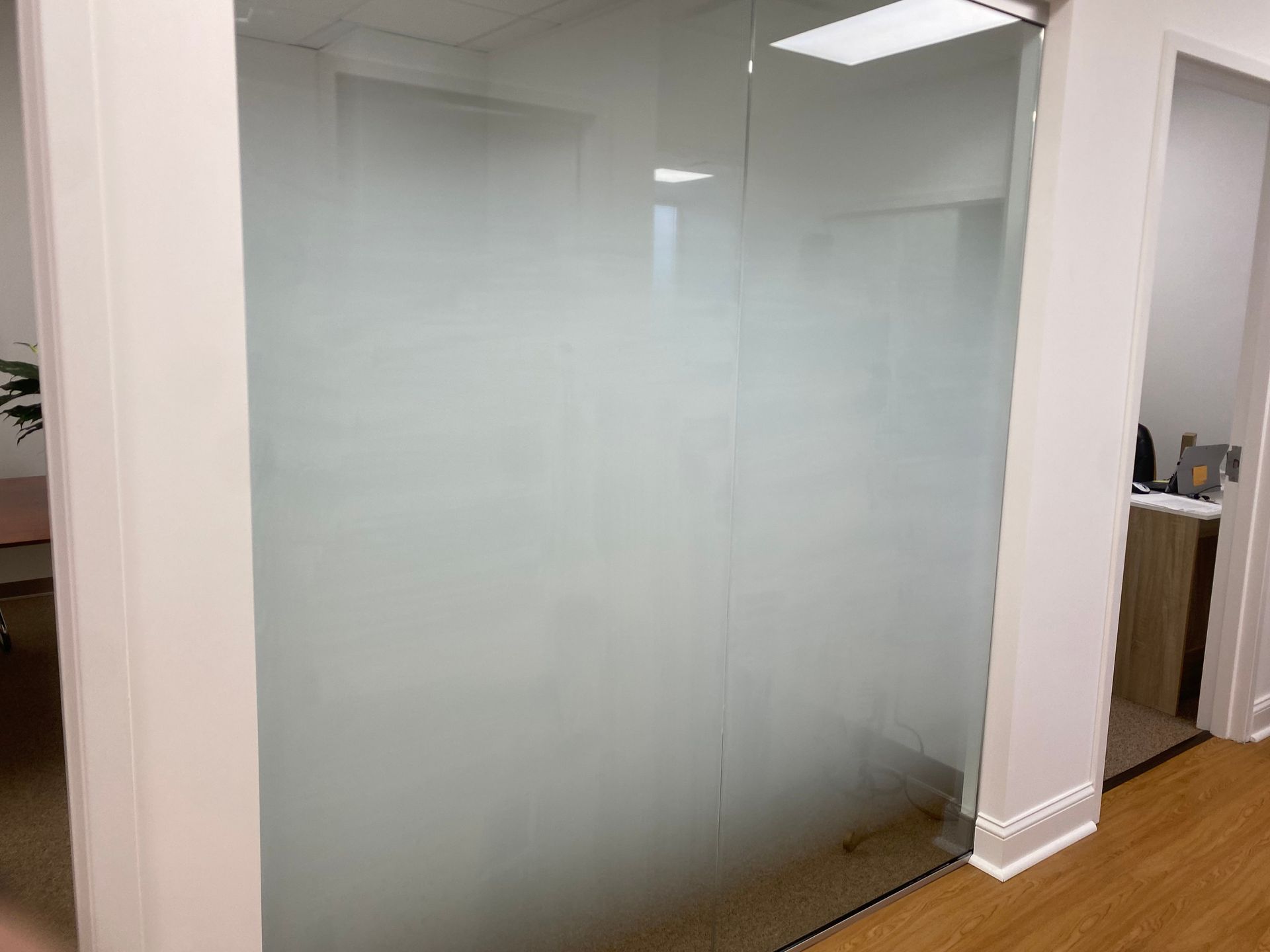 A room with a glass wall and a wooden floor.