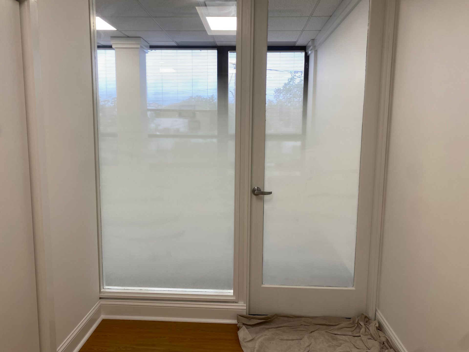 A hallway with a glass door and a window.
