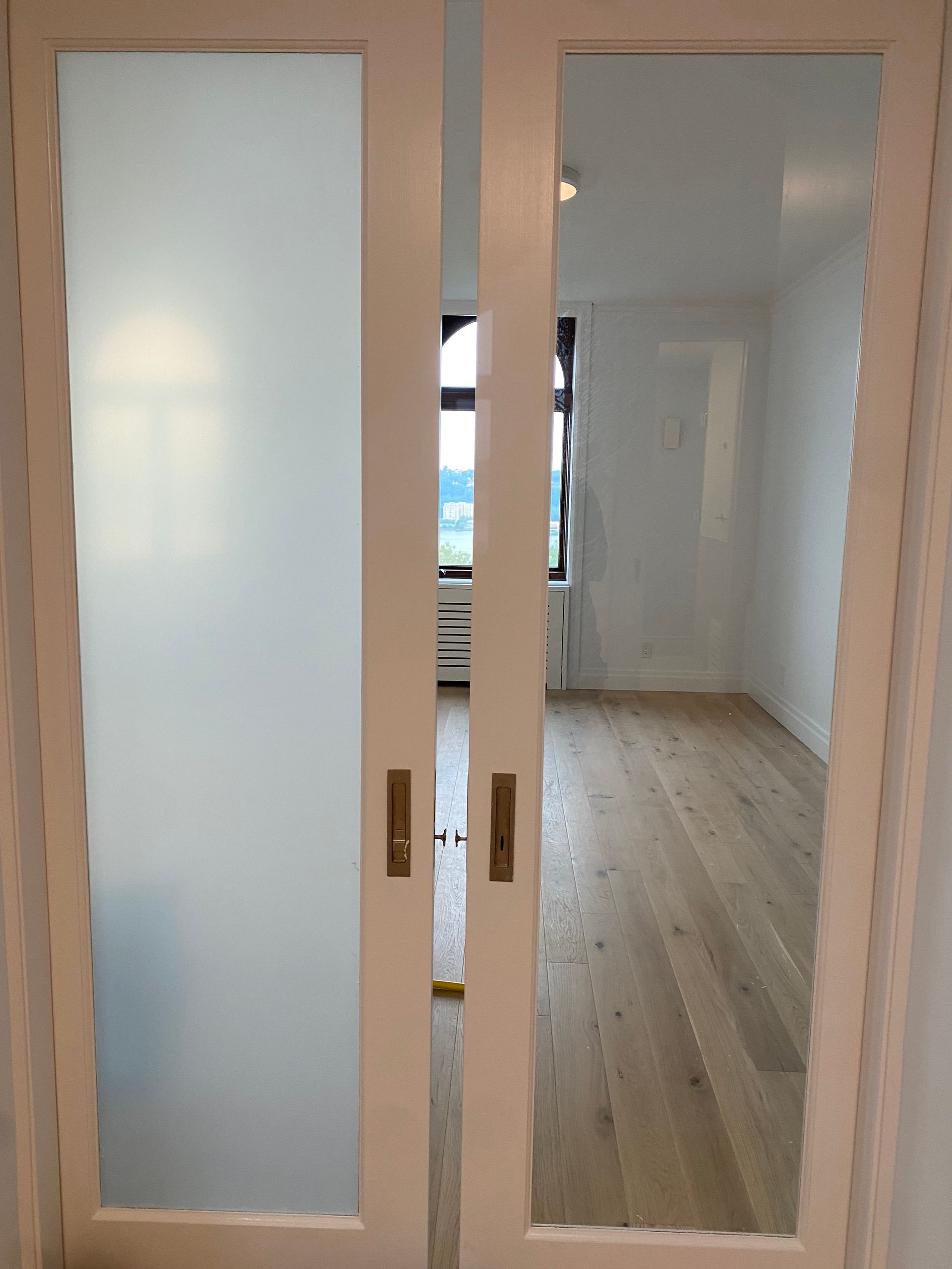 A pair of sliding glass doors leading into a room with hardwood floors.