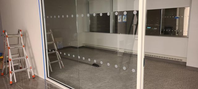 An empty room with a ladder and a glass door.