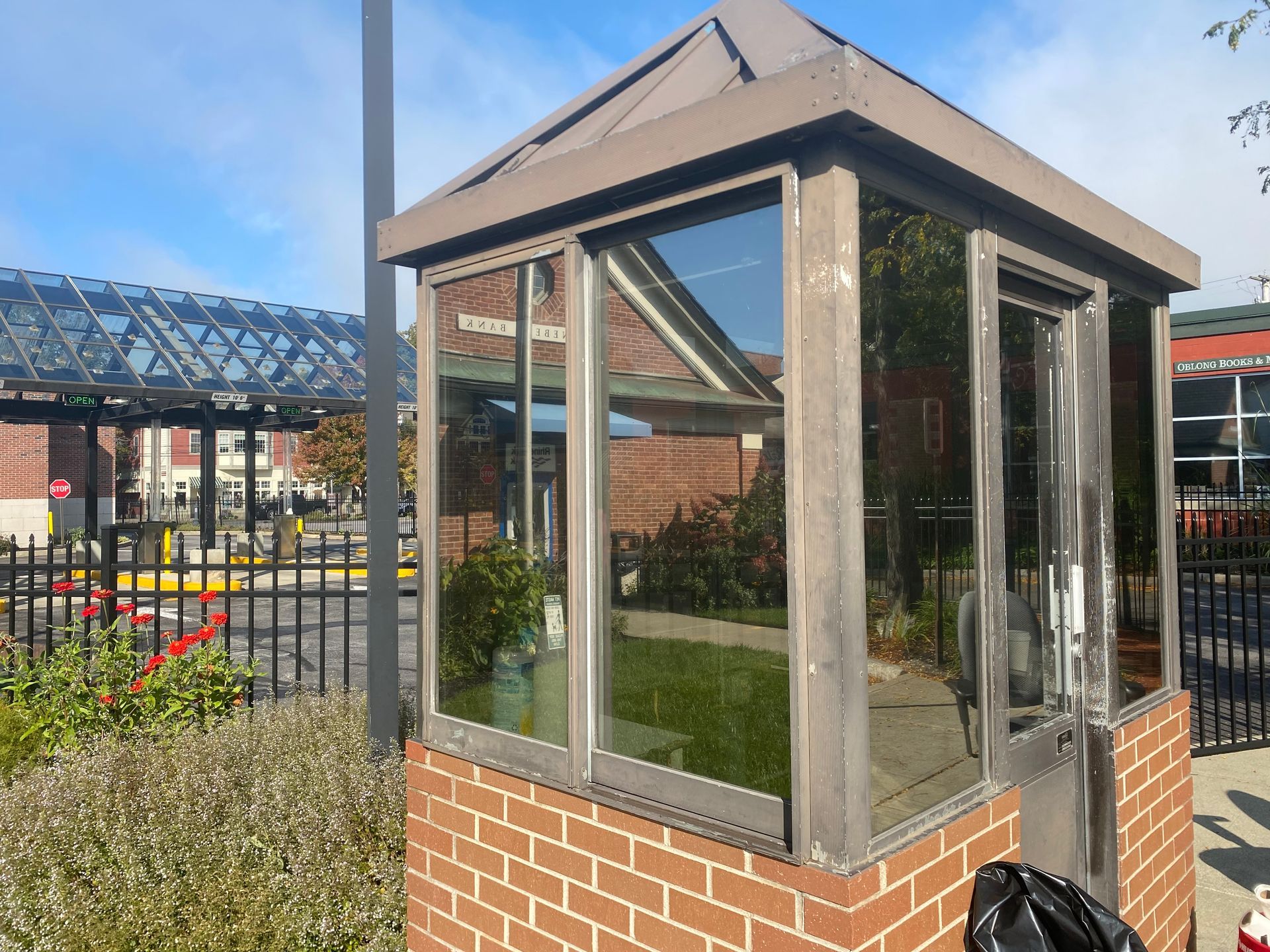 A small brick building with a roof and a lot of windows