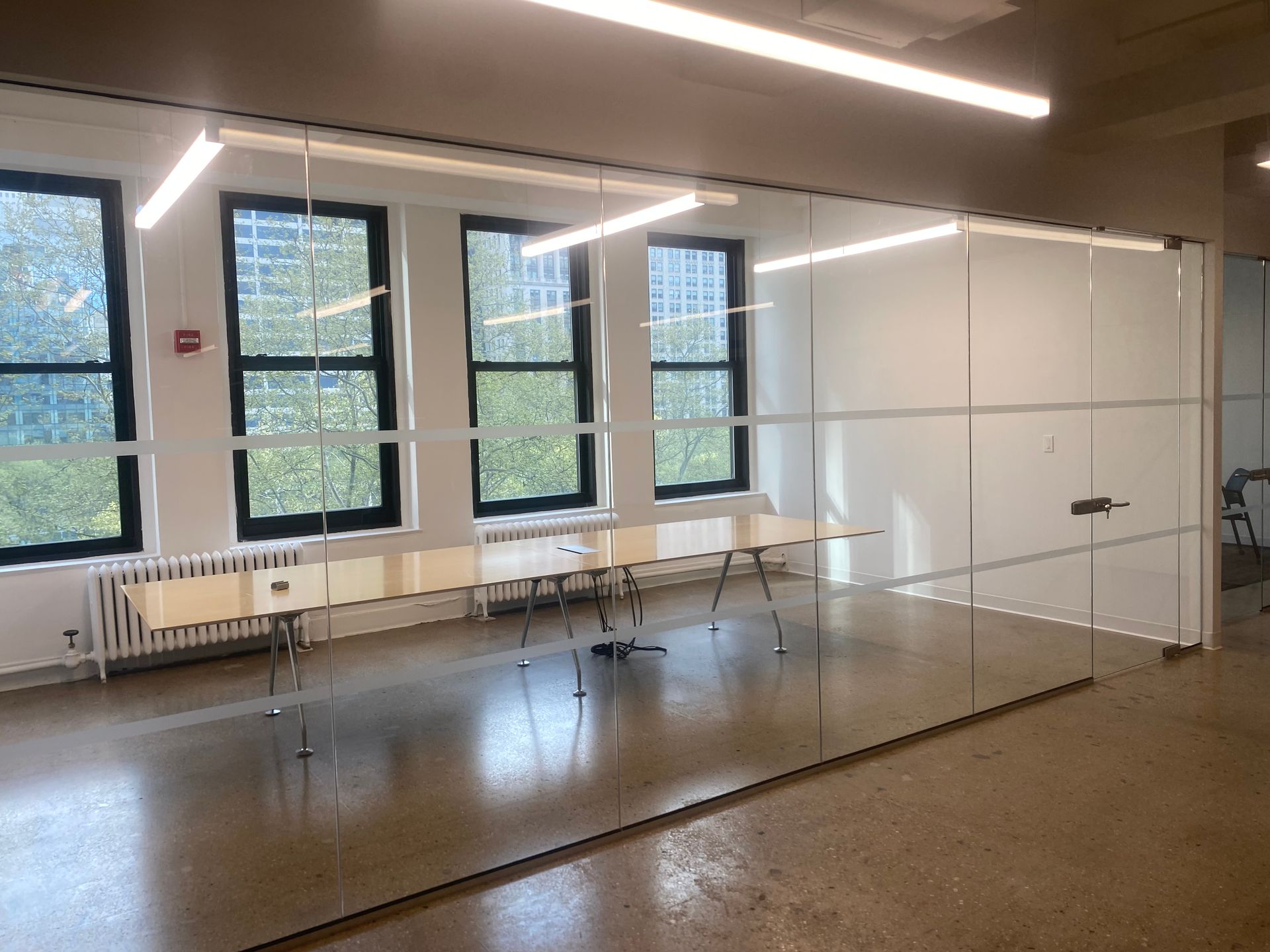 A room with a lot of windows and a fire extinguisher on the wall