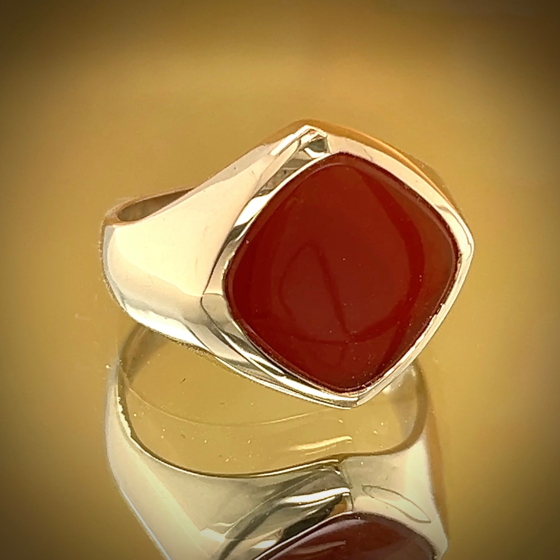 Silver ring with a large, square, reddish-brown gemstone.