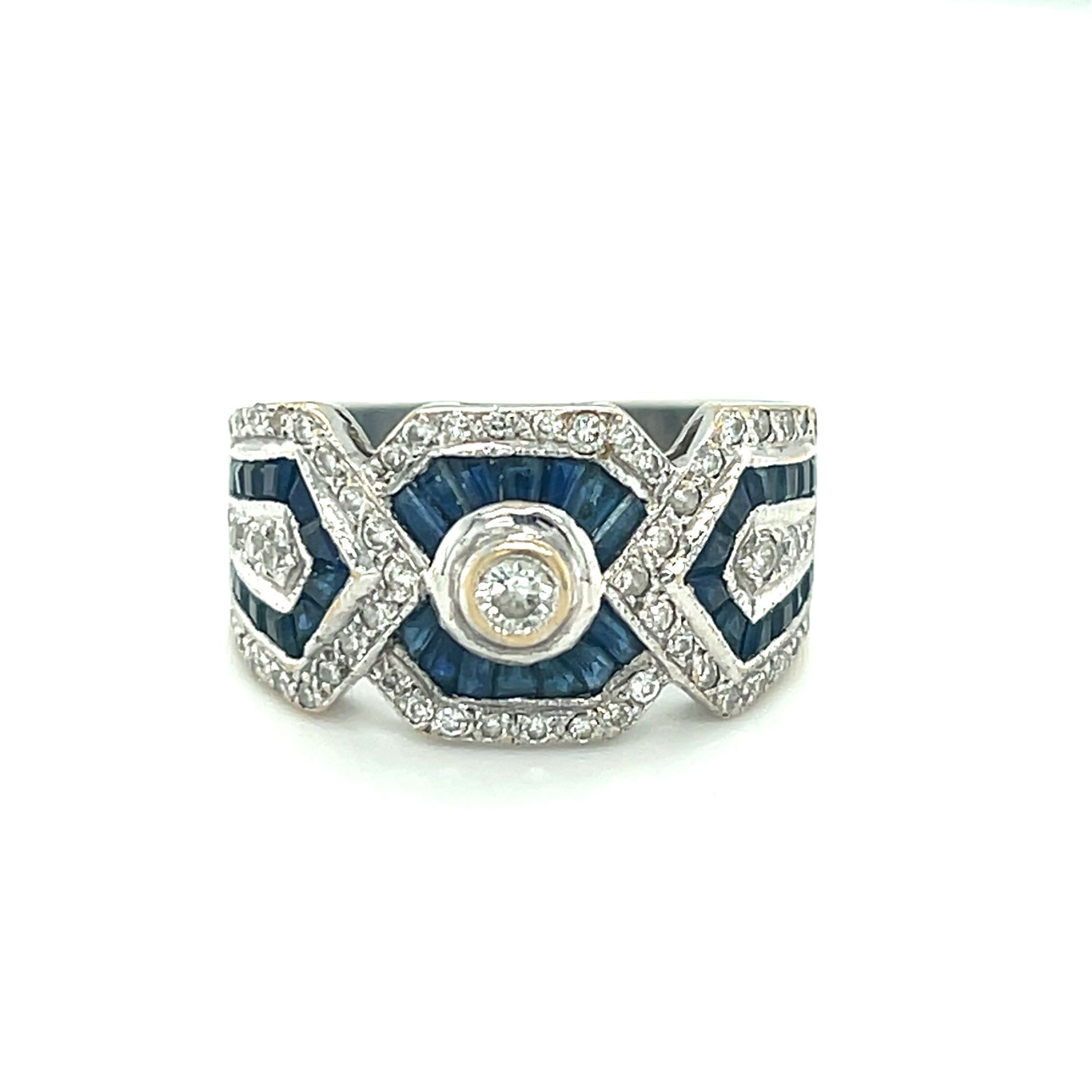 Diamond and sapphire Art Deco style ring with a central diamond surrounded by blue sapphire baguettes.