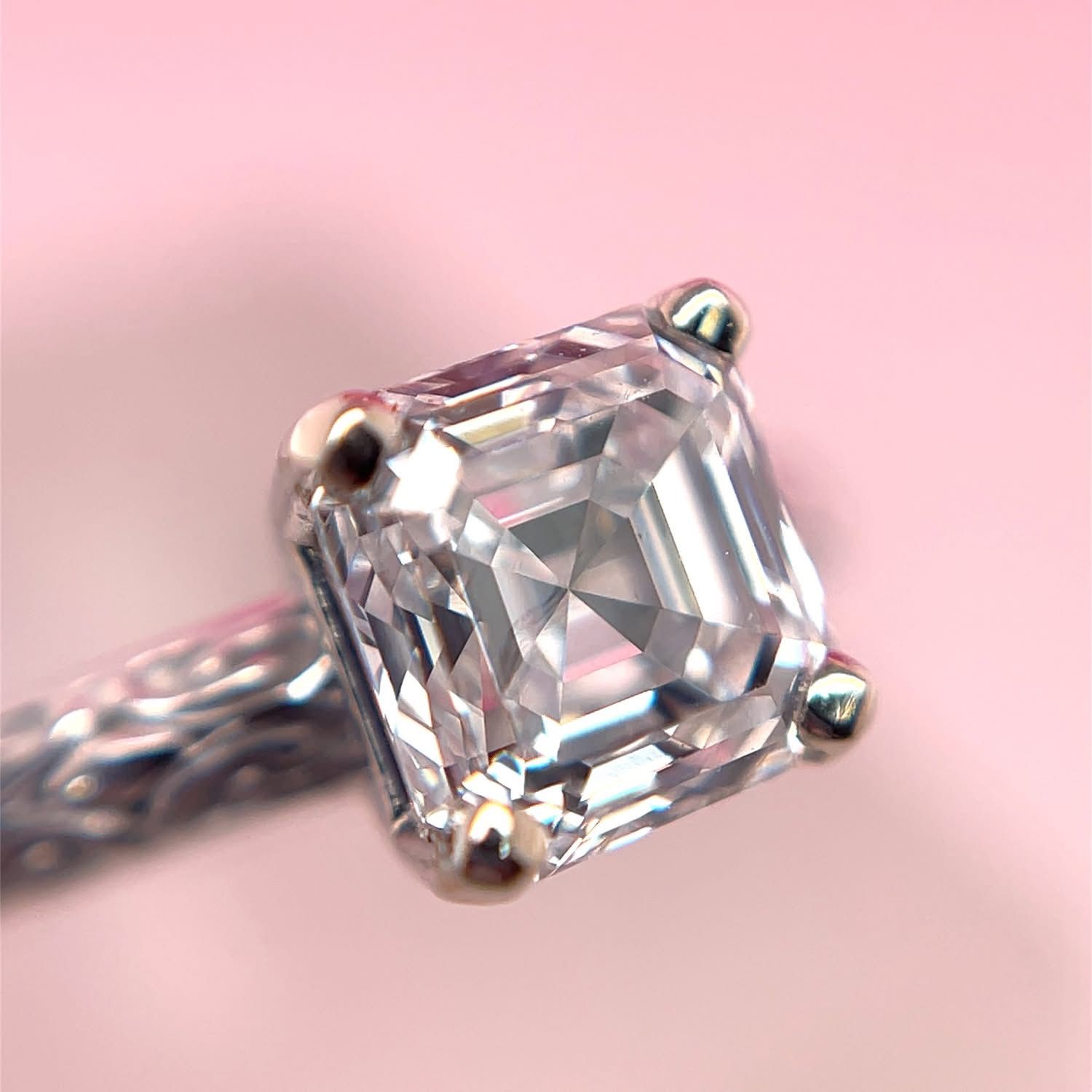 Diamond ring with a square-cut gemstone, set on a patterned silver band.