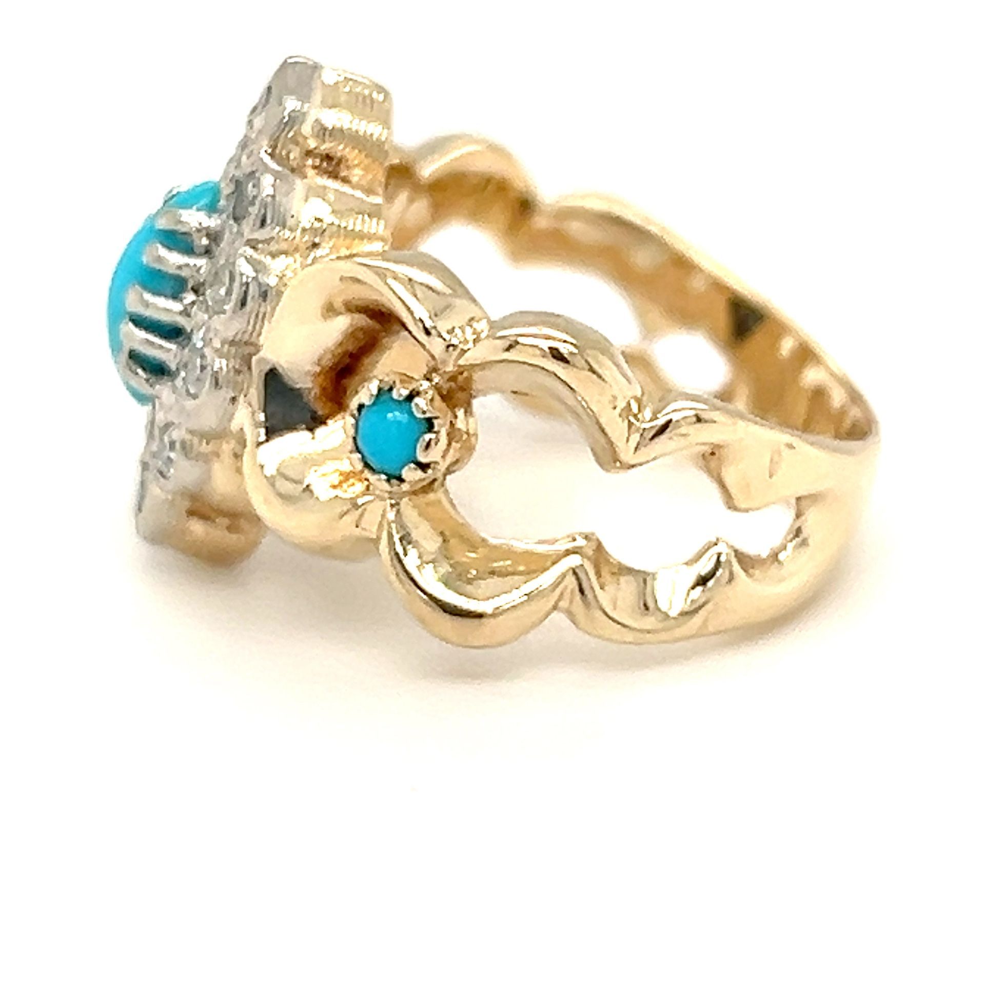 Gold ring with turquoise stones set in an ornate design.