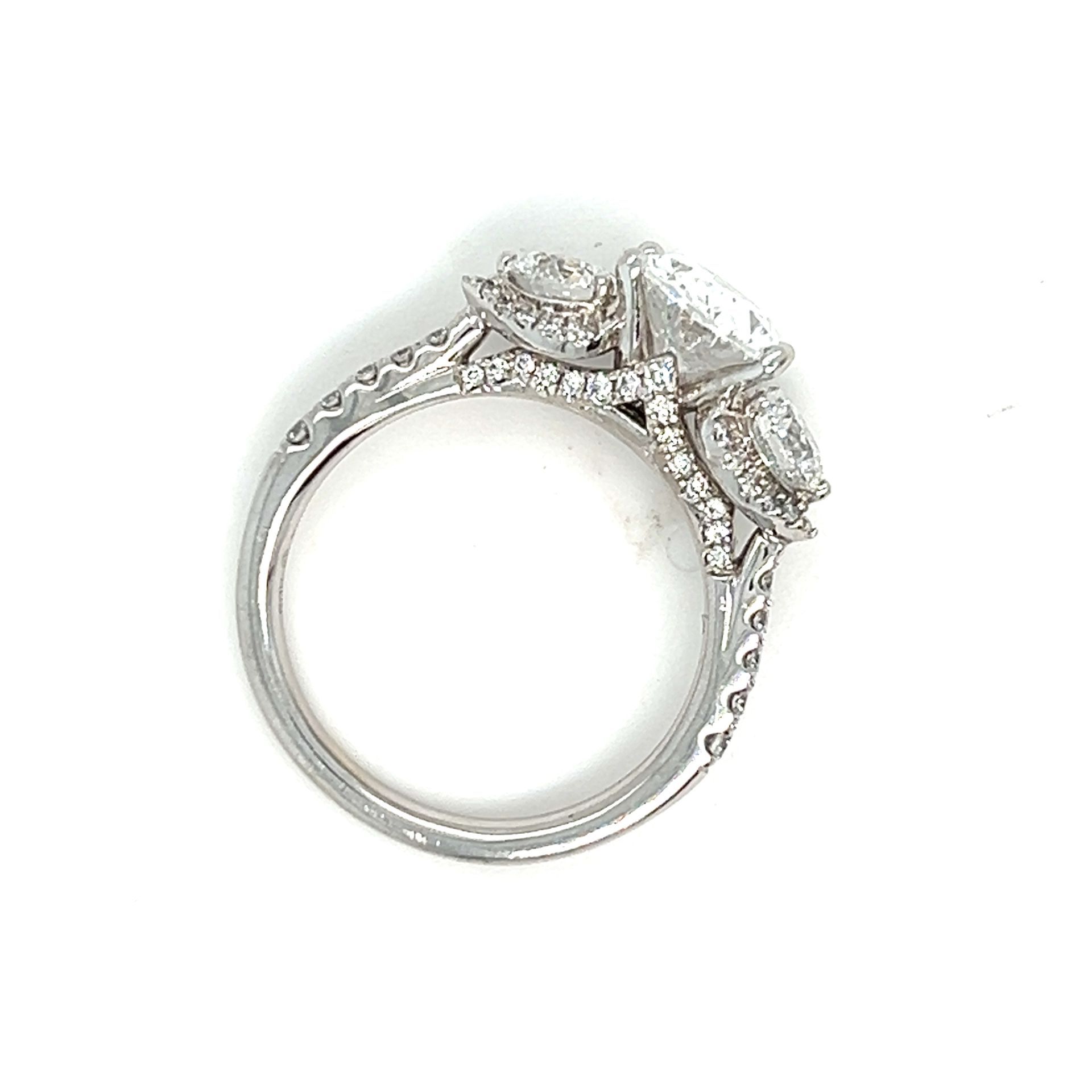 Diamond ring with a large center stone and smaller side stones, set in white metal.