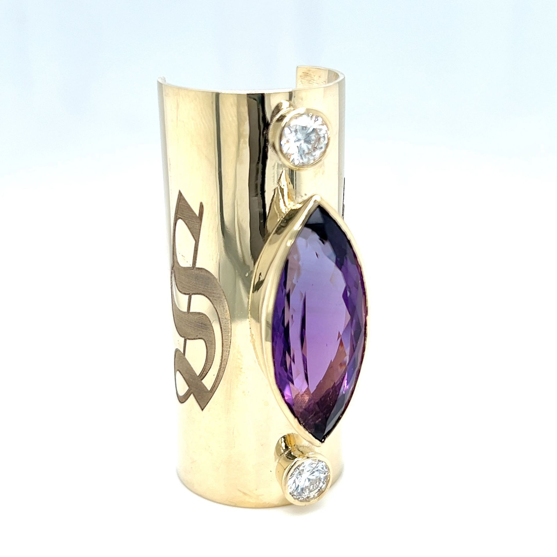 Gold ring with an amethyst and two white gemstones, with the letter 