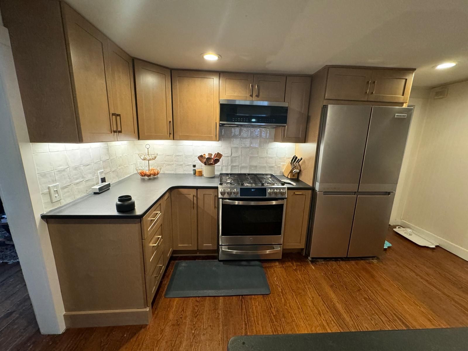 Kitchen with wooden cabinets, stainless steel appliances, and dark countertops.