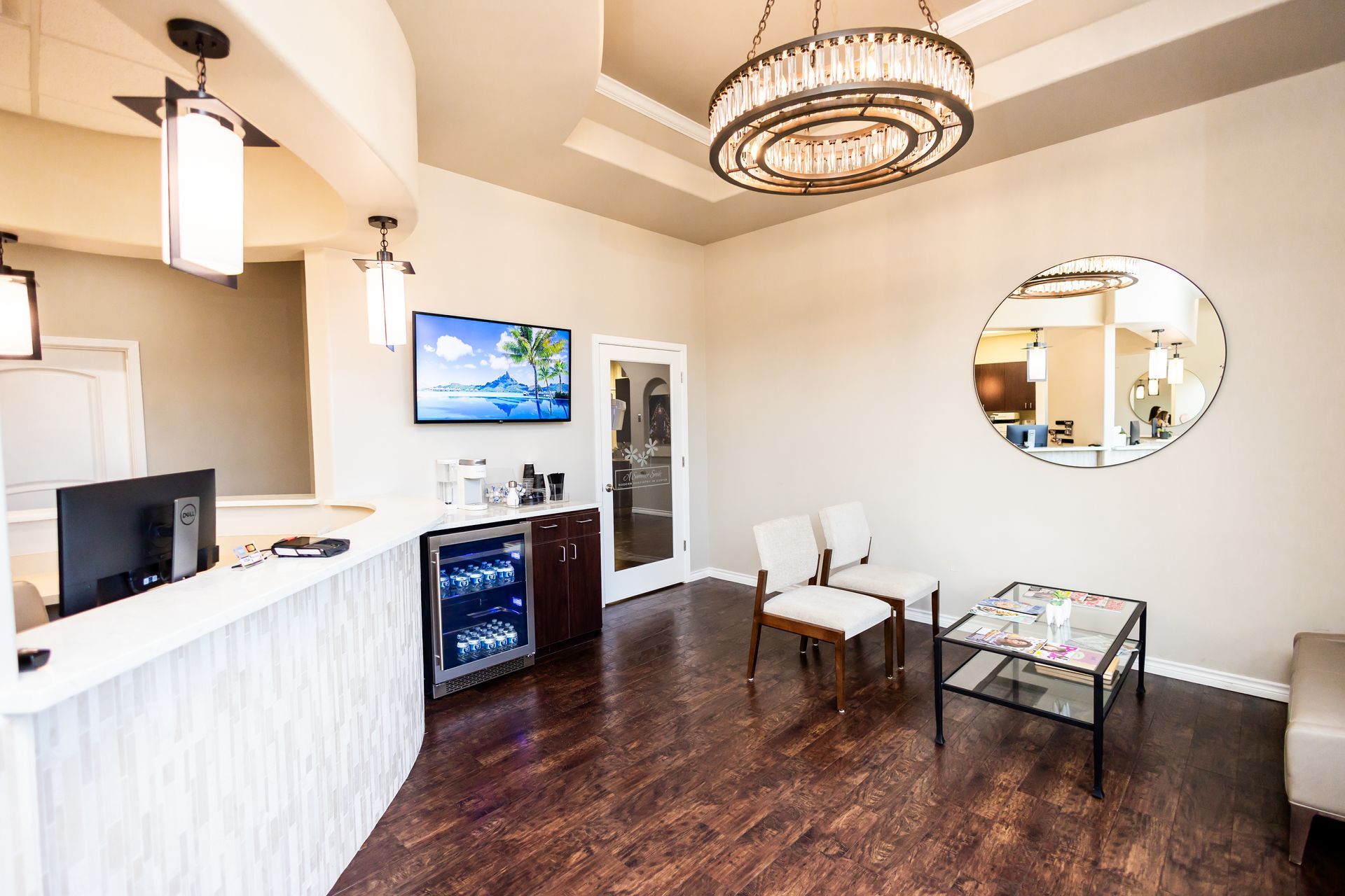 Reception area of a dental office with a desk, chairs, a TV, and a cooler.