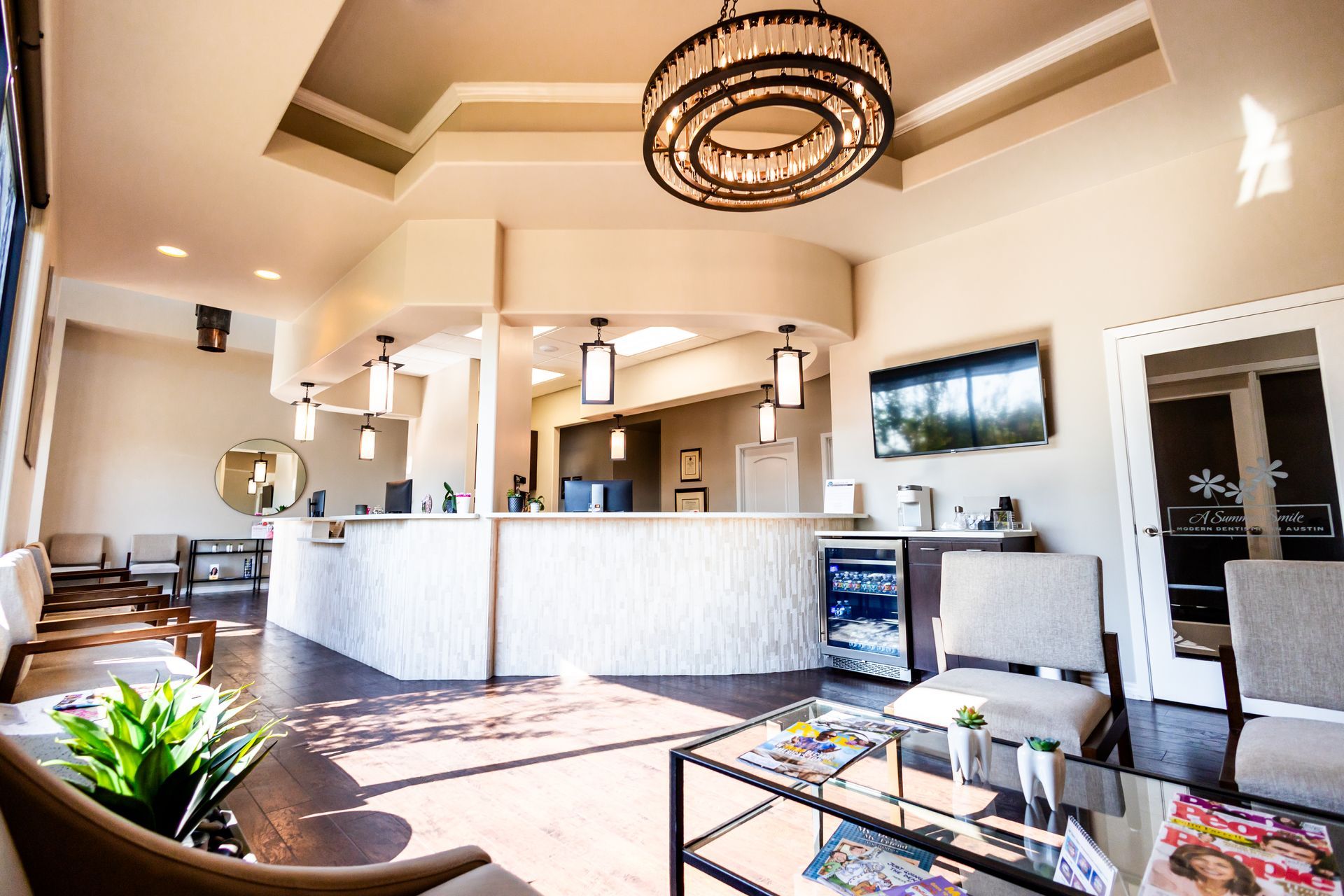 Modern waiting room with reception desk, chairs, and decorative lighting.