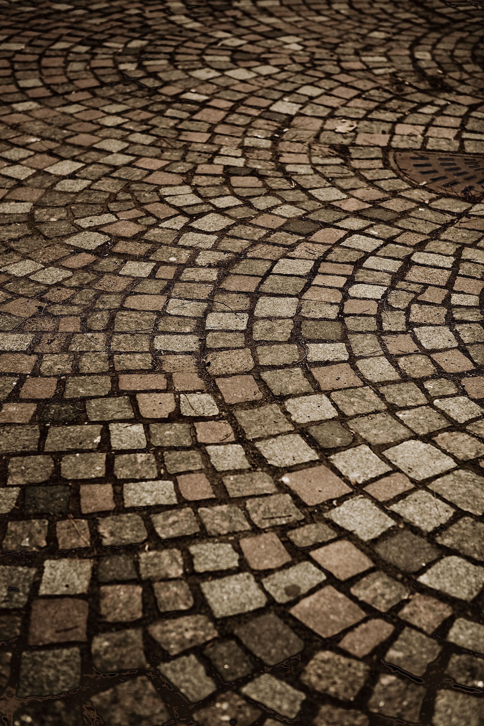 Curved cobblestone pavement in earthy brown tones, viewed from above