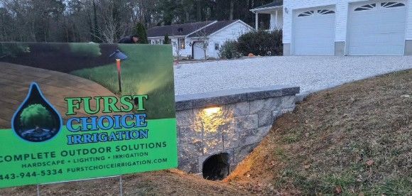 Furst Choice outdoor solutions sign in front of a house and retaining wall