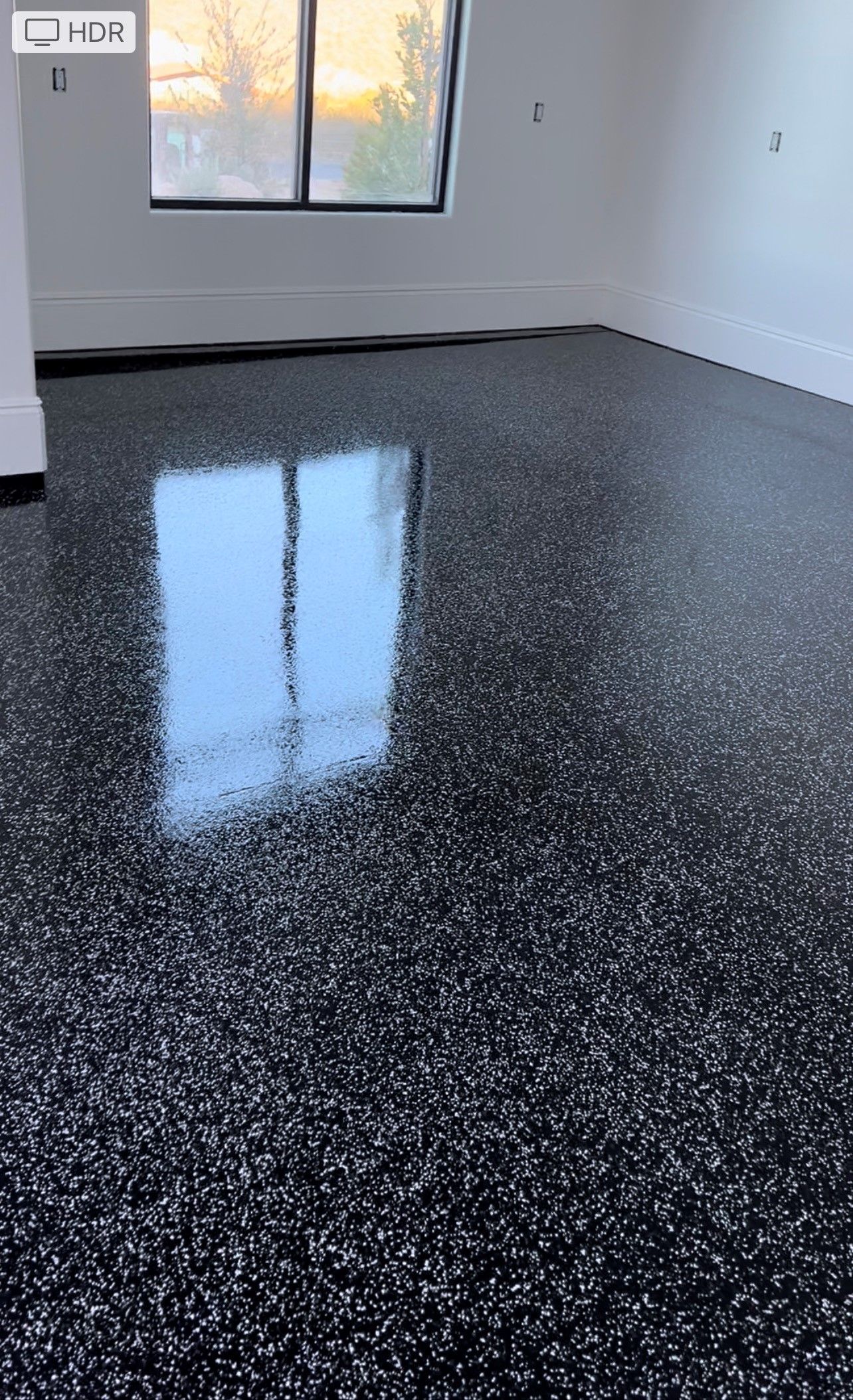 A room with a black and white floor and a window.