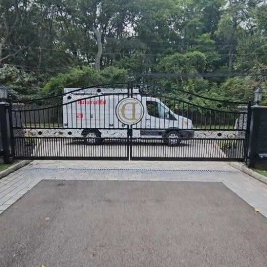 A white van is parked behind a metal gate