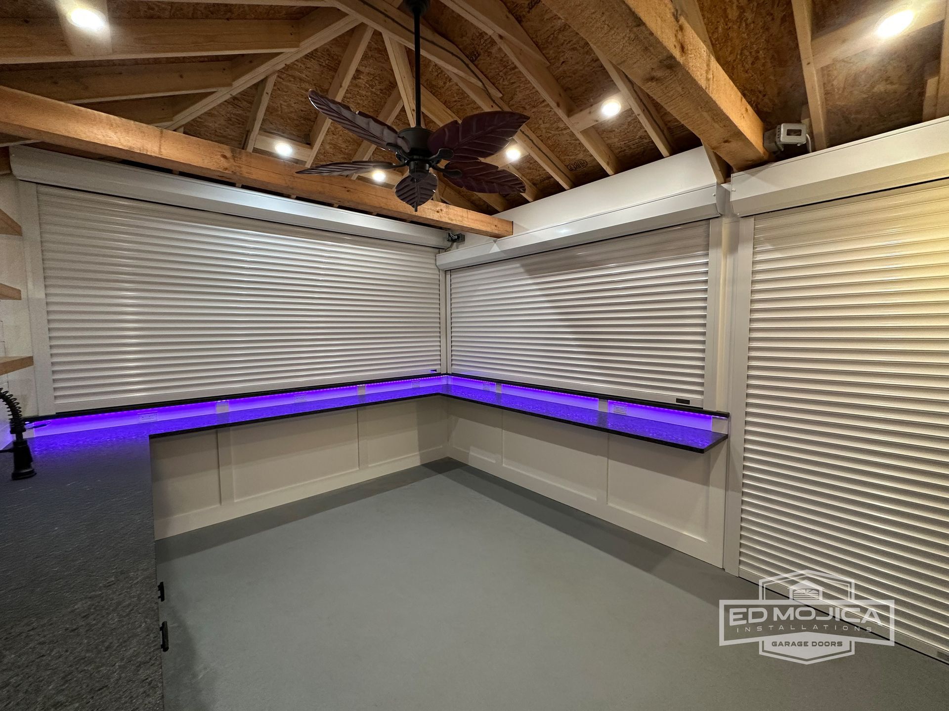 A room with a ceiling fan and purple lights on the walls